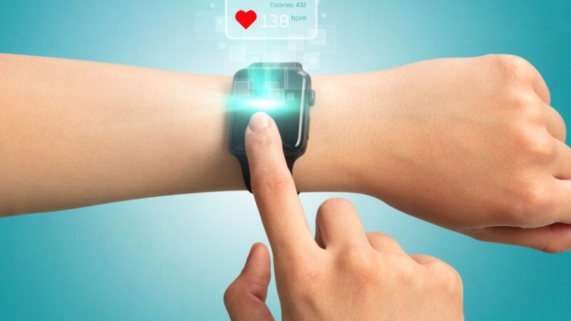 Main interagissant avec une montre connectée affichant des données sportives en réalité augmentée
