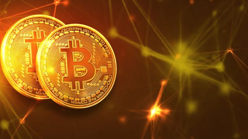 Pièces de Bitcoin dorées avec un arrière plan numérique lumineux représentant la blockchain