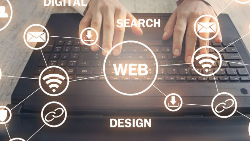Mains tapant sur un clavier dordinateur portable entouré dicônes et de mots clés liés au web marketing digital stratégie design internet