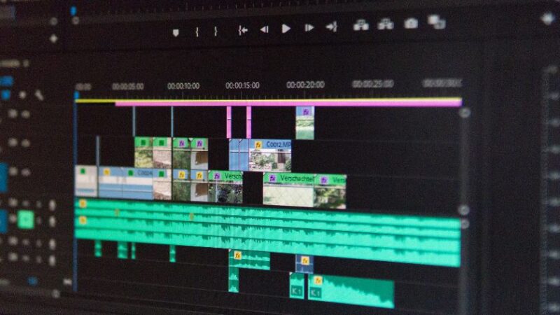 Écran dordinateur affichant un logiciel de montage vidéo avec plusieurs pistes audio et visuelles en cours dédition