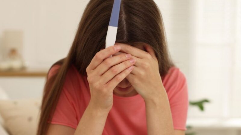 Femme préoccupée tenant un test médical à domicile dans ses mains