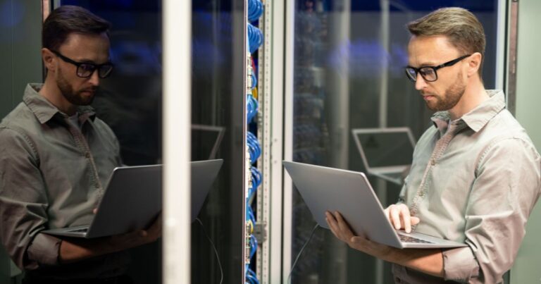 Administrateur système utilisant un ordinateur portable dans une salle de serveurs