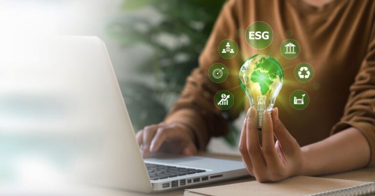 Personne tenant une ampoule verte représentant la planète Terre avec des icônes ESG autour