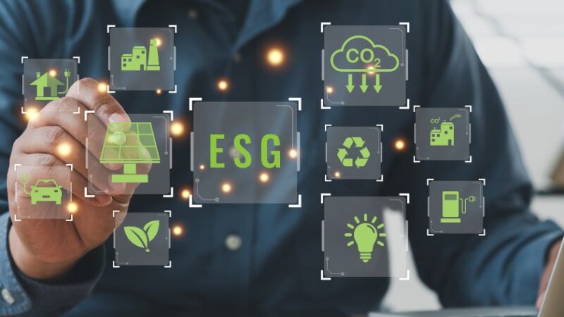 Main dun professionnel interagissant avec des icônes ESG numériques représentant lenvironnement le social et la gouvernance