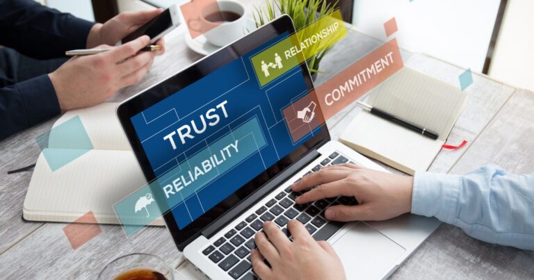Ordinateur portable affichant des mots clés Trust Reliability Relationship et Commitment pendant une réunion