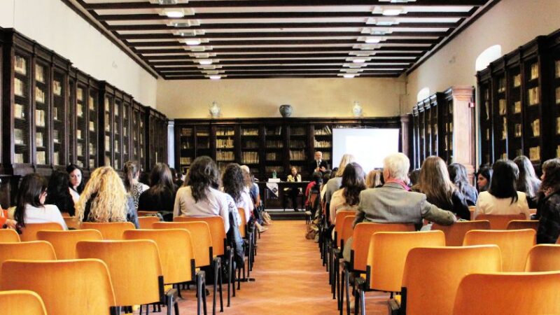 Conférence sur la formation continue dans une bibliothèque avec des participants assis face à un intervenant