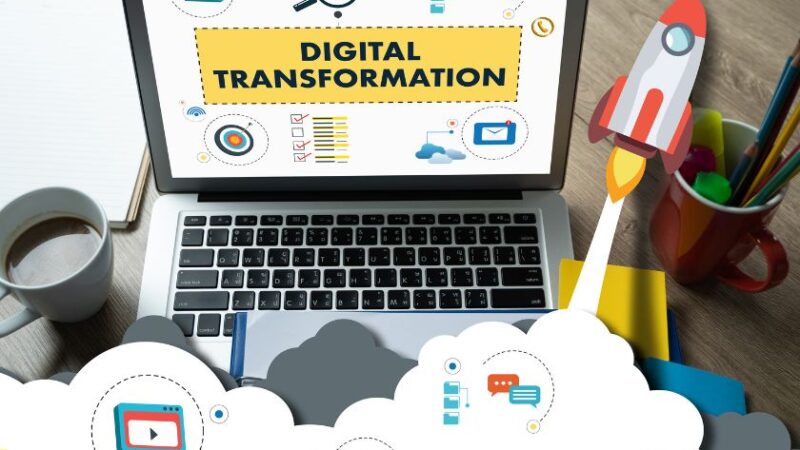 Ordinateur portable affichant Digital Transformation avec illustrations de fusée et dicônes numériques