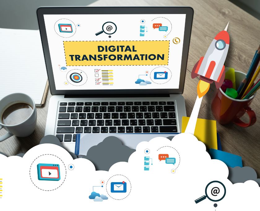 Ordinateur portable affichant Digital Transformation avec illustrations de fusée et dicônes numériques