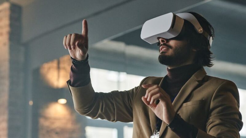 Homme en costume utilisant un casque de réalité virtuelle dans un environnement professionnel