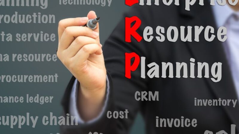 Personne écrivant ERP Enterprise Resource Planning entouré de mots clés liés à la gestion dentreprise