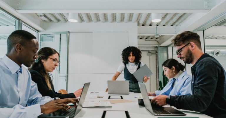 Réunion déquipe avec ordinateurs portables pour discuter des besoins de formation informatique