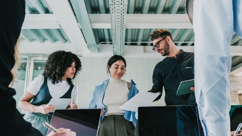 Équipe en réunion discutant des besoins de formation informatique autour dune table