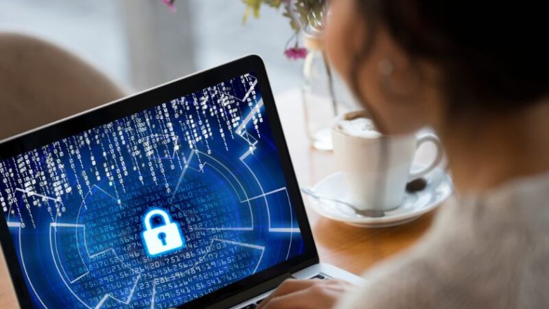 Femme utilisant un ordinateur portable affichant un cadenas numérique pour la cybersécurité