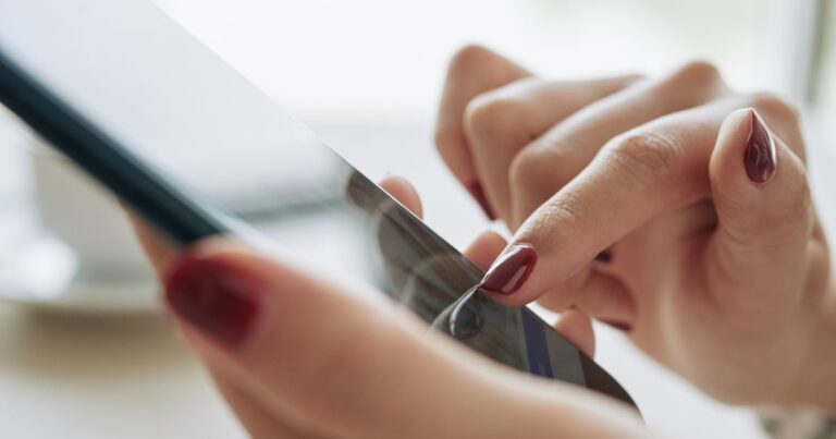 Gros plan sur des mains féminines utilisant un smartphone tactile illustrant linteraction mobile et lexpérience utilisateur numérique